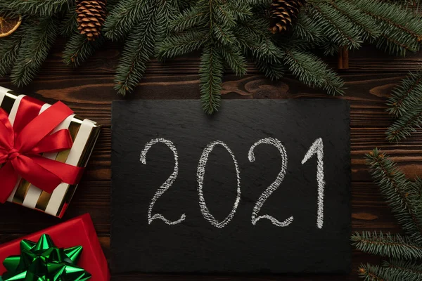 Masanın üzerinde 2021 yazısıyla süslenmiş siyah bir granit plaket var..