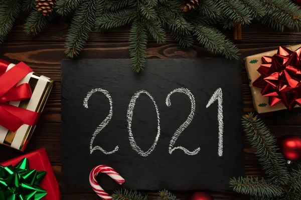 Masanın üzerinde 2021 yazısıyla süslenmiş siyah bir granit plaket var..