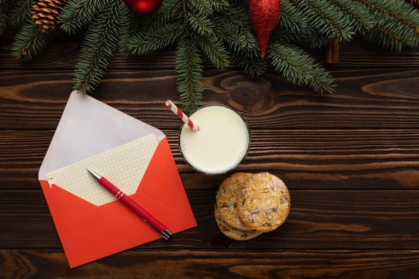 Masanın üzerinde Noel için dileklerin yanı sıra Noel Baba için hediyeler olan bir mektup var. Yeni yıl dekoruyla süslenmiş bir masa..
