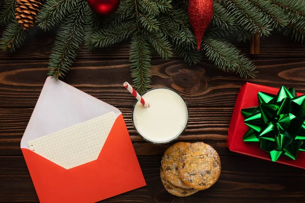 Masanın üzerinde Noel için dileklerin yanı sıra Noel Baba için hediyeler olan bir mektup var. Yeni yıl dekoruyla süslenmiş bir masa..