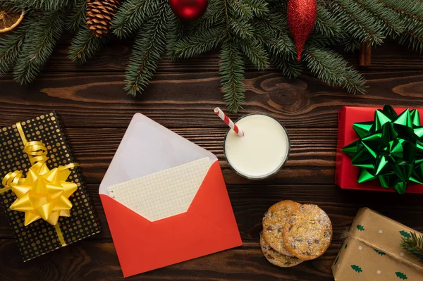 Masanın üzerinde Noel için dileklerin yanı sıra Noel Baba için hediyeler olan bir mektup var. Yeni yıl dekoruyla süslenmiş bir masa..