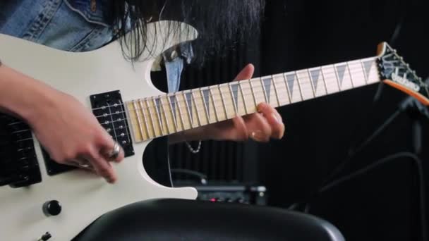 Manos sosteniendo una guitarra eléctrica blanca y tocando un solo rápido — Vídeo de stock