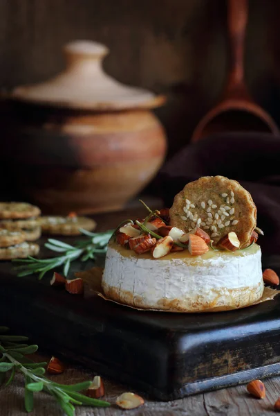 Baked cheese with almonds, rosemary, honey and crackers — Stock Photo, Image