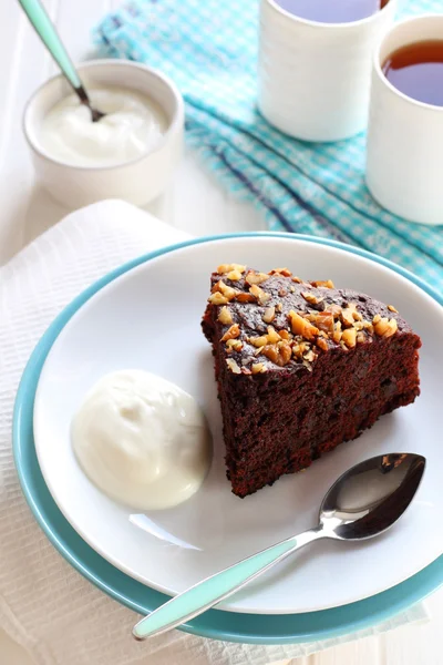 Pezzo di torta al cioccolato con noci servita con yogurt — Foto Stock