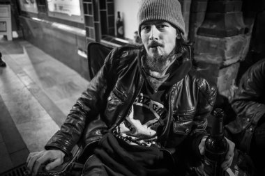 Evsiz adam oturuyor, bira içiyor, sigara içiyor..