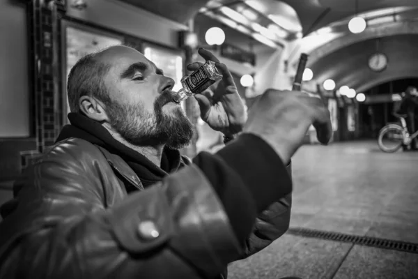 Adam bir sigara tutuyor ve Berlin 'de yeraltında viski içiyor..
