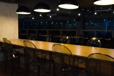 Sarı masa ve şeffaf plastik sandalye ile boş kafeterya