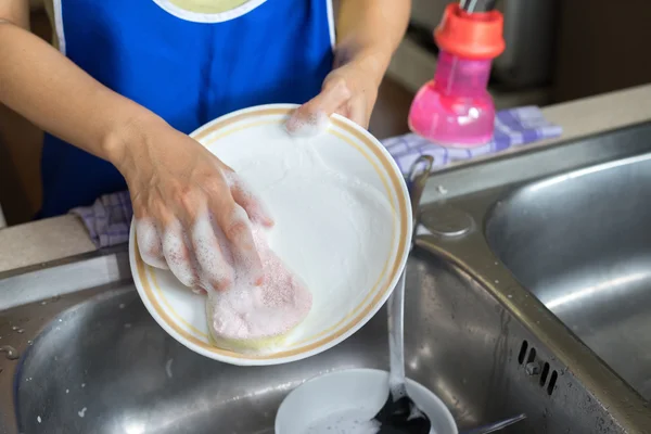 Female hand washing white dish with sponge — Stock Photo, Image