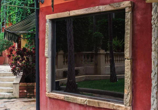 Reflexão na janela de vidro na parede vermelha — Fotografia de Stock
