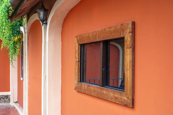 Janela emoldurada de madeira na parede laranja — Fotografia de Stock