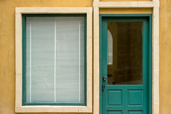 Finestra e porta in legno verde su parete gialla — Foto Stock