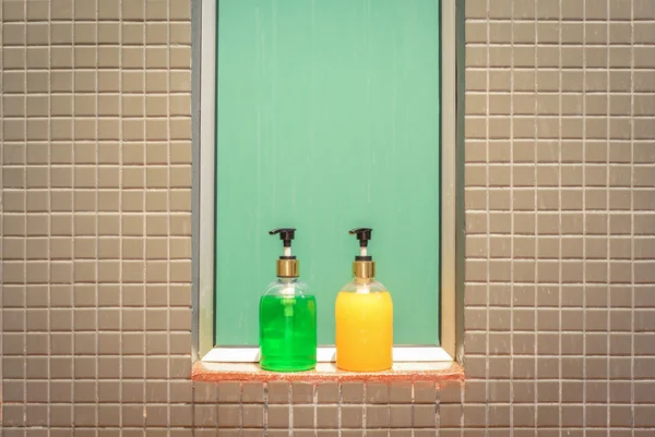 Botellas amarillas y verdes de jabón líquido y champú en el baño —  Fotos de Stock