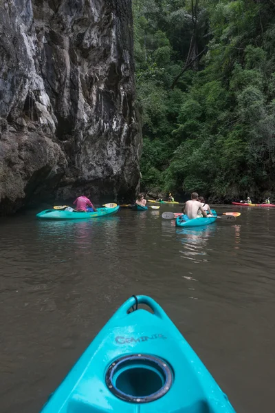 Туристы в красочных каяках под скалой и джунглями — стоковое фото