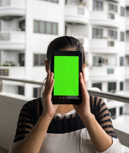 Asiatisk kvinna anläggning tablet i hennes händer med vita byggnaden i bakgrunden — Stockfoto