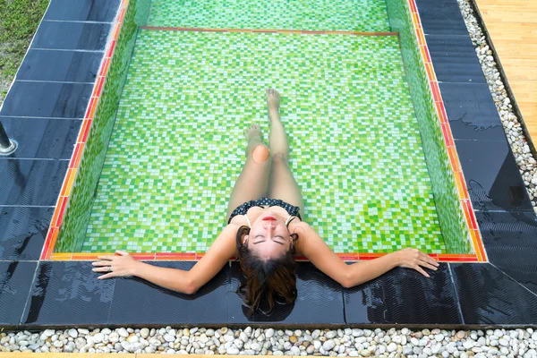 Asiatische Mädchen liegend in die Schwimmbad — Stockfoto