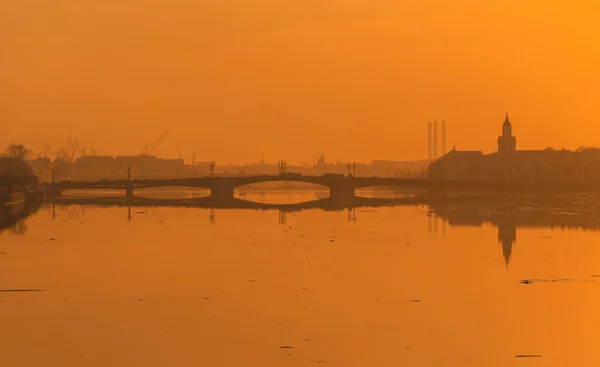 O pôr do sol sobre o rio Neva e em seus aterros — Fotografia de Stock