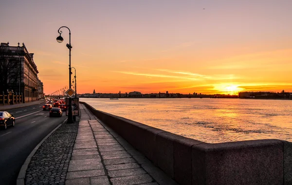 O pôr do sol sobre o rio Neva e em seus aterros — Fotografia de Stock