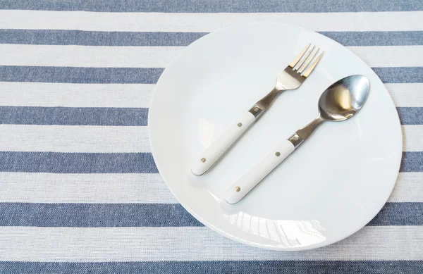 Stainless Steel Spoon and Fork on White Ceramic Plate Laid on Wh — Stock Photo, Image