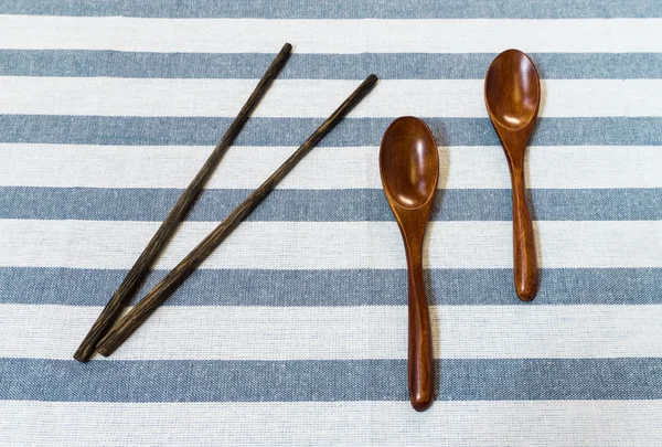 Dwa drewniane łyżki i chińskie pałeczki na białym tle pasiasty — Zdjęcie stockowe