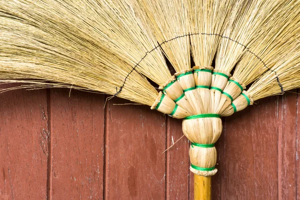 Broom Stick Lay on a Brown Wooden Door Stok Gambar