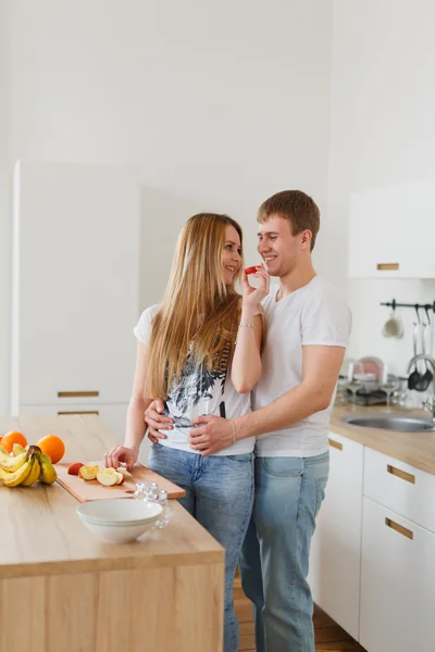 Young couple cooking - man and woman in their kitchen — Stock Photo, Image