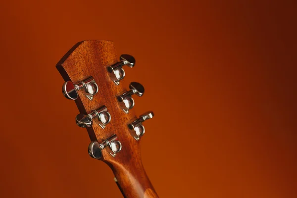 six-string acoustic guitar on a red background