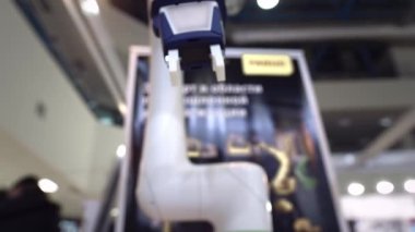 Manipülatörün kolu parçayı masadan kaldırır. Modern mühendislik teknolojileri. Endüstri için robot kolu. Yapay Zeka.