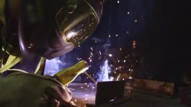 Fabrika işçisi metali kaynaklıyor. Adam kaynak yapıyor. Argon ya da elektrot kaynaklama. Metal yapılar üreten bir endüstri şirketi.