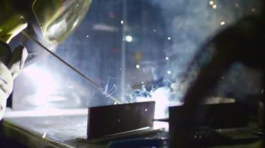 Fabrika işçisi metali kaynaklıyor. Adam kaynak yapıyor. Argon ya da elektrot kaynaklama. Metal yapılar üreten bir endüstri şirketi.