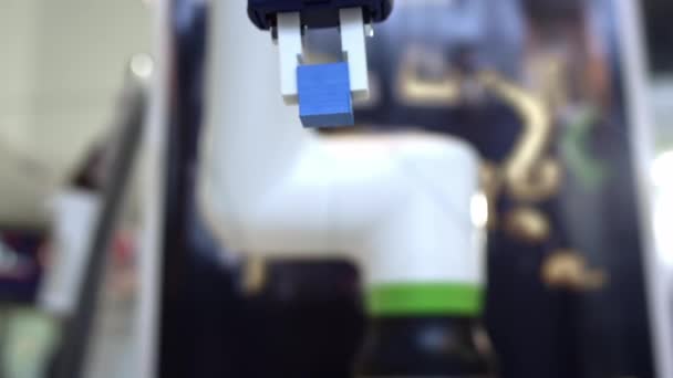 Футуристическая рука робота собирает и перемещает цветные кубики, искусственный интеллект контролирует моторику роботов. — стоковое видео