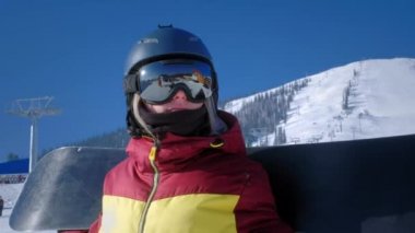 Dağ yamacına bakan güzel bir kızın portresi. Maskeli ya da snowboard gözlüklü bir turist geleceğe bakar. Sporda zafer kavramı. Kayak merkezinde kış seyahati