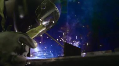 Fabrika işçisi metali kaynaklıyor. Adam kaynak yapıyor. Argon ya da elektrot kaynaklama. Metal yapılar üreten bir endüstri şirketi.