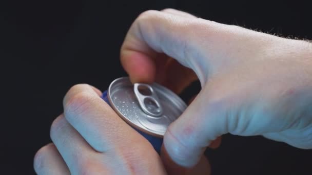 Un hombre tiene una lata de aluminio en sus manos. Abre la tapa de cerveza o refresco con el dedo. Descanse por la noche, bebiendo alcohol. Movimiento lento. — Vídeos de Stock