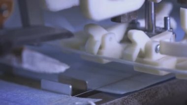 Hava filtresi için tıbbi koruyucu yüz maskesi üretimi. Coronavirus koruma makinesi, covid-19. Çelik makas, maskeyi yüze tutturmak için ipi kesti. Makro üretim hattı, taşıyıcı