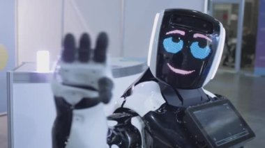 Modern Robot Teknolojileri. Modern beyaz robot. Kameraya teknolojik robot dalgaları. Günlük hayatta yeni teknolojiler. Dans etmek..