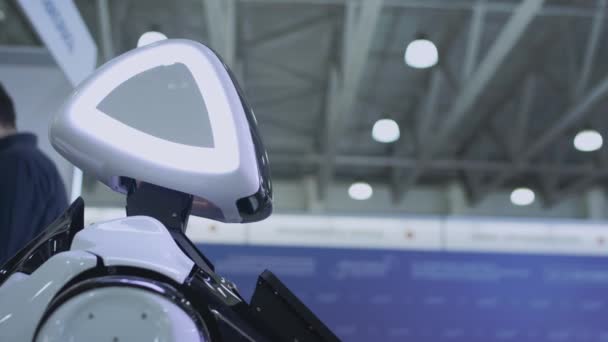 Σύγχρονες ρομποτικές τεχνολογίες. Το ρομπότ κοιτάζει την κάμερα στο πρόσωπο. Το ρομπότ δείχνει συναισθήματα. Σηκώνει τα χέρια του ψηλά, χορεύει ή αγανακτεί. Ή επιθέσεις — Αρχείο Βίντεο