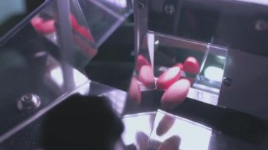 Turuncu haplar ya da besin takviyeleri taşıyıcı boyunca ilerler. İlaç ve tıbbi malzeme üretimi. Tablet üretimi. İlaç Endüstrisi Tabletli Taşıma Hattı, Fabrika Ekipmanı.