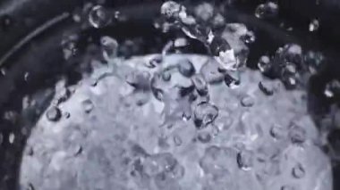 Siyah bas woofer. Sudan hoparlör. Su damlacıkları bas sesiyle patlar. Hoparlörden sıvı sıçraması. Parti ya da konser için arka plan. Yavaş çekim.