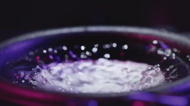 Güçlü ses hoparlörlerinin mavi neon ışığa toz atması soyut bir kavram. Güç müziği. Titrek bir hoparlör neon ışığına sıvı su atar. Kayıt stüdyosunda bas sesi. Geri dalga konsepti.