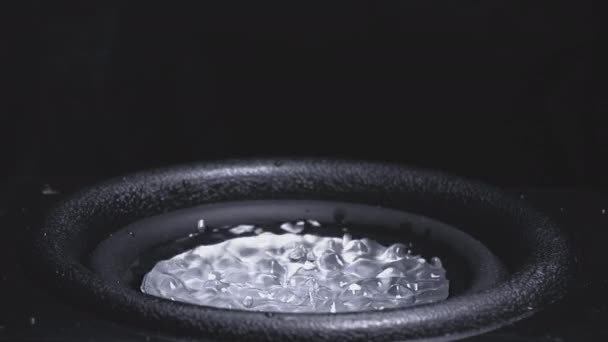 Σκούρο κύμα ήχου και μαύρο νερό υγρό σε ένα πιάτο. Subwoofer ηχείο με νερό. Σταγόνες εκρήγνυνται πάνω από τον ήχο του μπάσου. Υγρό άλμα στο ηχείο ήχου. Ιστορικό για ένα πάρτι. Αργή κίνηση. — Αρχείο Βίντεο