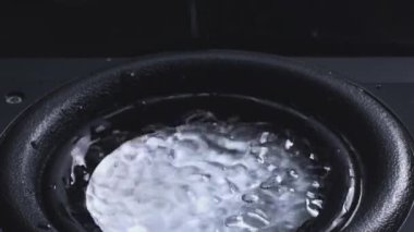 Karanlık Dalga Ses ve Siyah Su Tabağı 'ndaki Sıvı. Sudan hoparlör. Damlacıklar bas sesiyle patlar. Hoparlörden sıvı sıçraması. Bir parti için arka plan. Yavaş çekim.