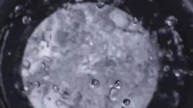 Siyah bas woofer. Sudan hoparlör. Su damlacıkları bas sesiyle patlar. Hoparlörden sıvı sıçraması. Parti ya da konser için arka plan. Yavaş çekim.