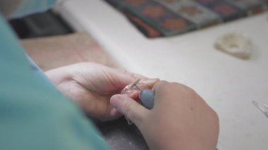 Yetişkin kadın doktor laboratuvarda görünmez diş telleri yaratıyor. Cerrah, Invisalign 'i çıkarılabilir olarak elinde tutuyor. Dişçilikte gelişmiş teknoloji. Yapay diş üretimi.