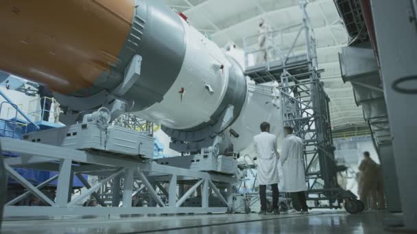 Dois engenheiros cientistas inspeccionam a nave espacial, escrevem no tablet. Um foguete espacial num hangar militar a ser preparado para o lançamento. Tecnologias espaciais. Construção de Big Rocket. A Humanidade no Espaço. — Vídeo de Stock