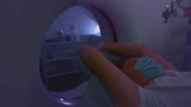 Koruyucu tıbbi maskeli bir hasta modern bir bilgisayarlı tomografi cihazında yatıyor. Doktor tomografide akciğerleri analiz ediyor. Covid ya da Coronavirus tehlikesi. İnsan akciğer taramaları.