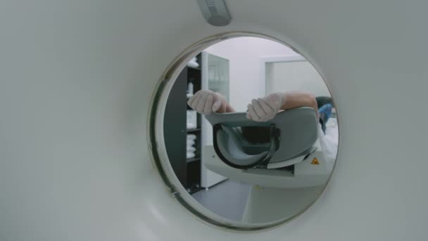 Un paciente con una máscara médica está acostado en una moderna máquina de tomografía computarizada. El médico analiza los pulmones con una tomografía computarizada. El peligro de covidio o coronavirus. Examinar el órgano de los pulmones. — Vídeo de stock