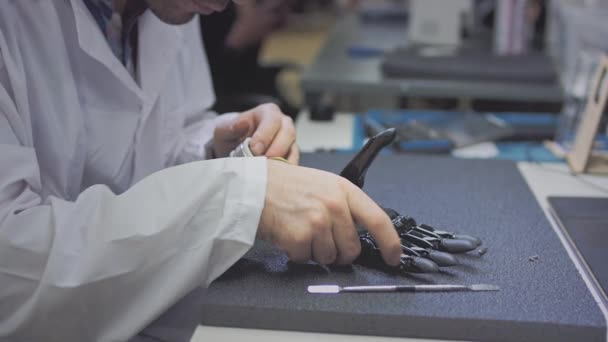Producción de una mano protésica. Un ingeniero científico crea o diagnostica una prótesis de brazo robótico. Laboratorio protésico. Un brazo mecánico para una vida plena. Creación de extremidades cibernéticas — Vídeos de Stock
