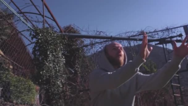 El jugador lanza con éxito la pelota en el aro, marca un punto, un gol de tres puntos. Un hombre hace driblar en un patio de la calle, lanza una pelota en una canasta de baloncesto. Motivación deportiva — Vídeos de Stock