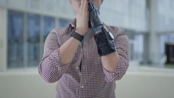 A man with a prosthetic arm. Artificial robotic arm, replaces hand and palm. A full life of a disabled person — Vídeo de Stock