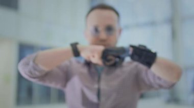 A man with a prosthetic arm. Artificial robotic arm, replaces hand and palm. A full life of a disabled person